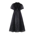 Front view black polka dot maxi dress, lapel collar, puff short sleeves, decorative pearl buttons, waist fitted long maxi skirt