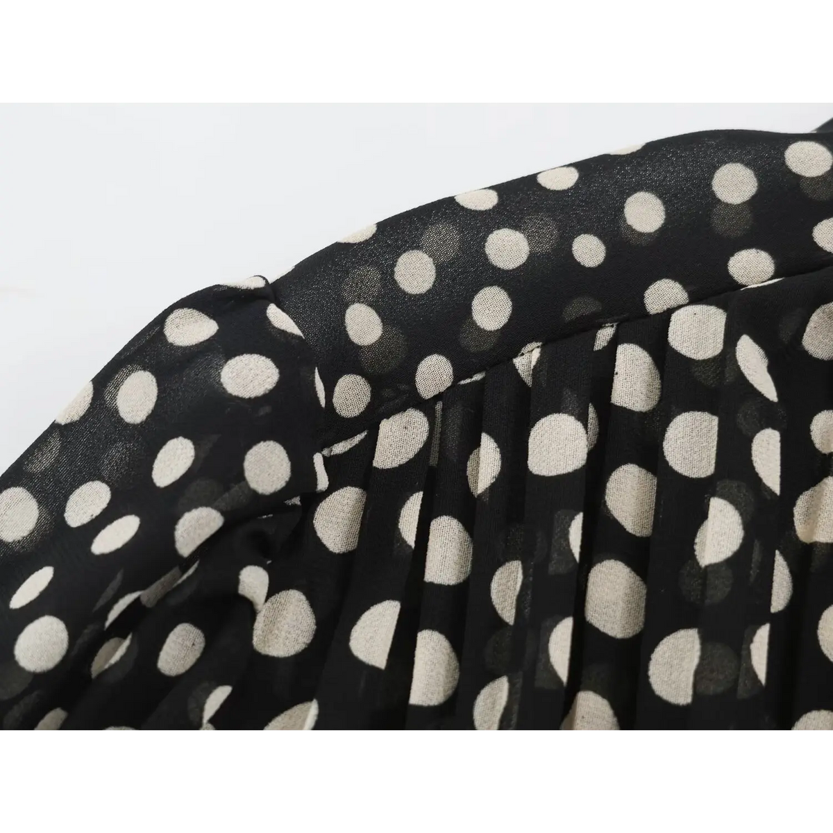 Close-up of shoulder stitching and seam detail on black polka dot maxi dress