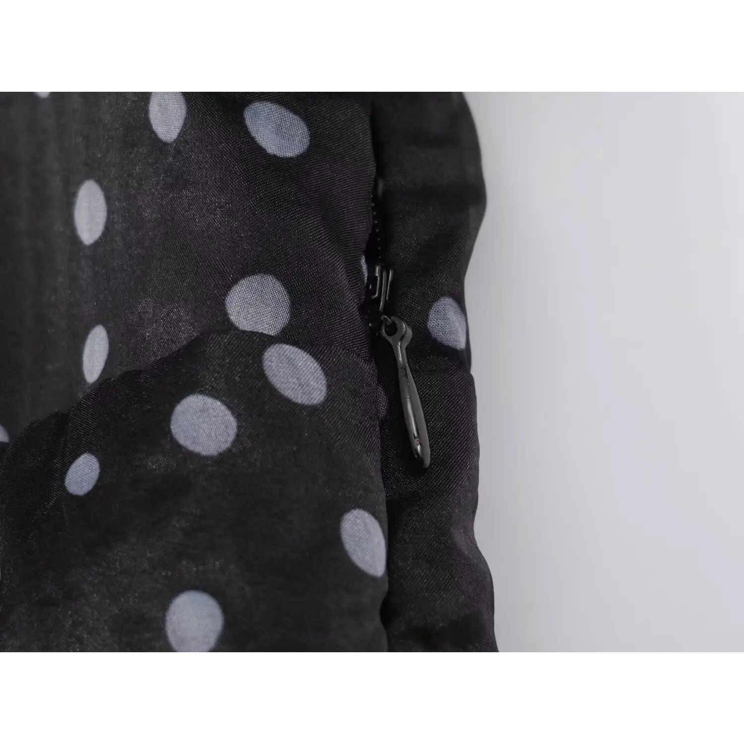 Close‑up of hidden side zipper on black polka dot organza maxi dress