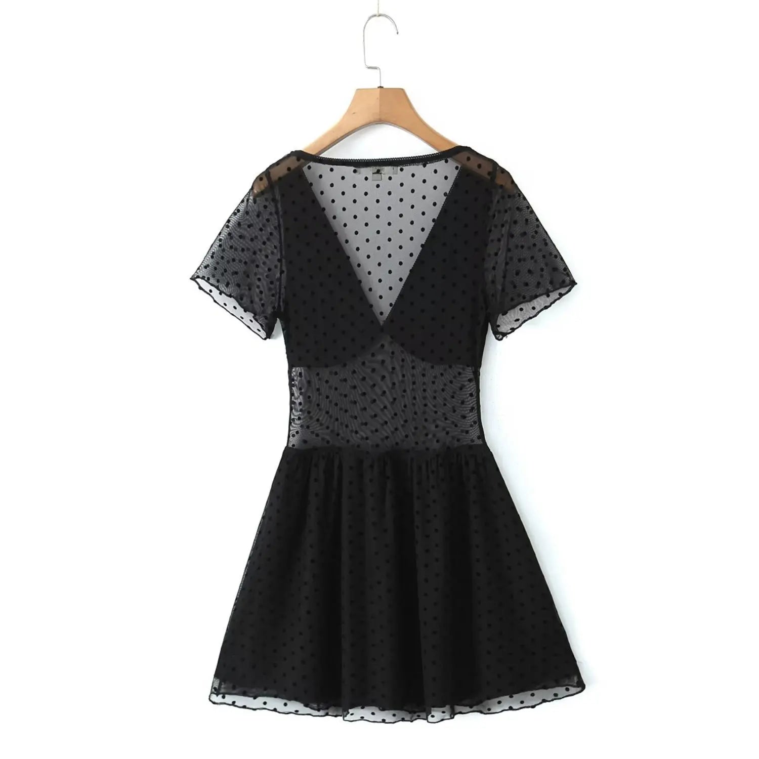 Back view black polka dot mesh mini dress hanging on wooden hanger, deep v‑back short sleeve design