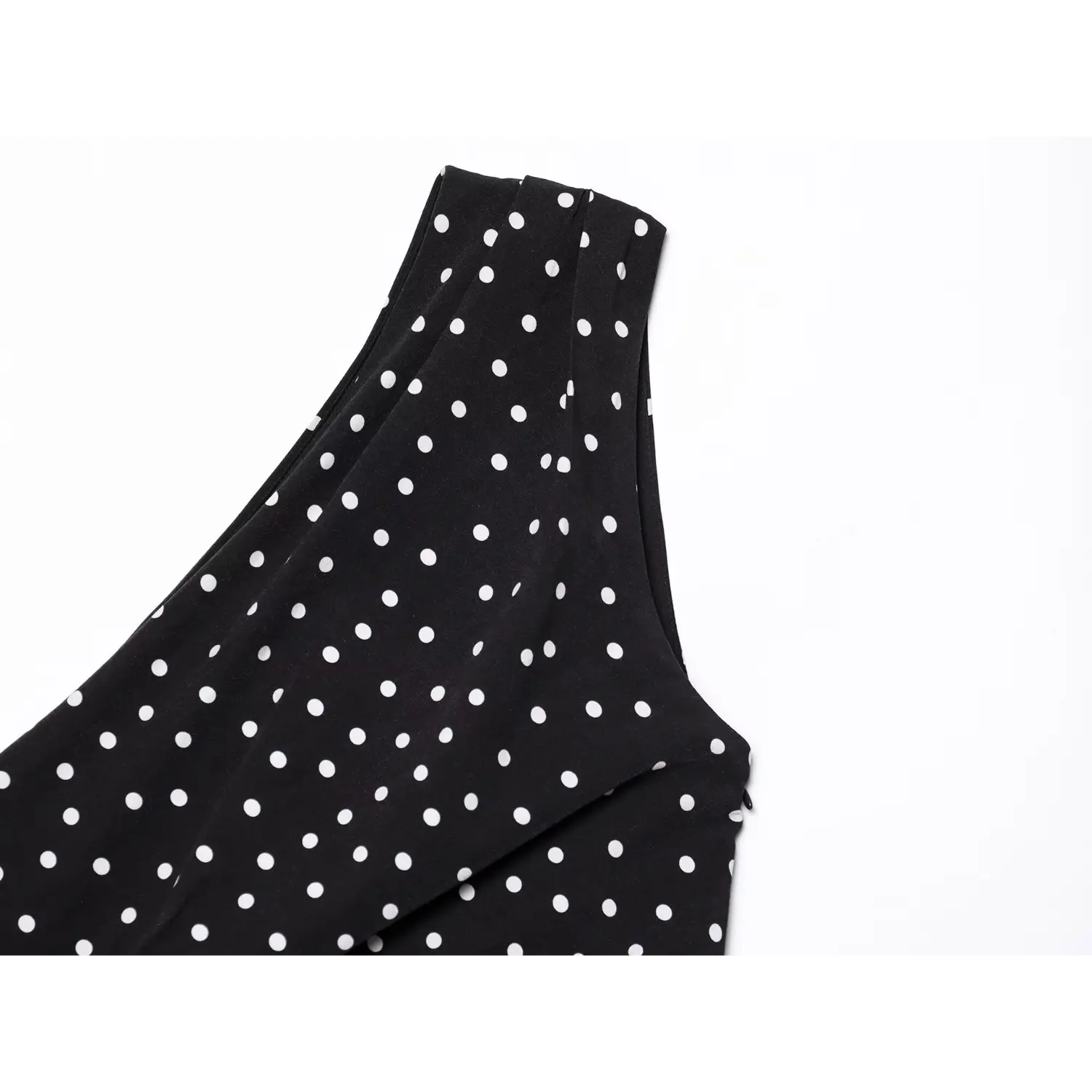 Close‑up one‑shoulder neckline pleat detail black dress all‑over white polka dot pattern