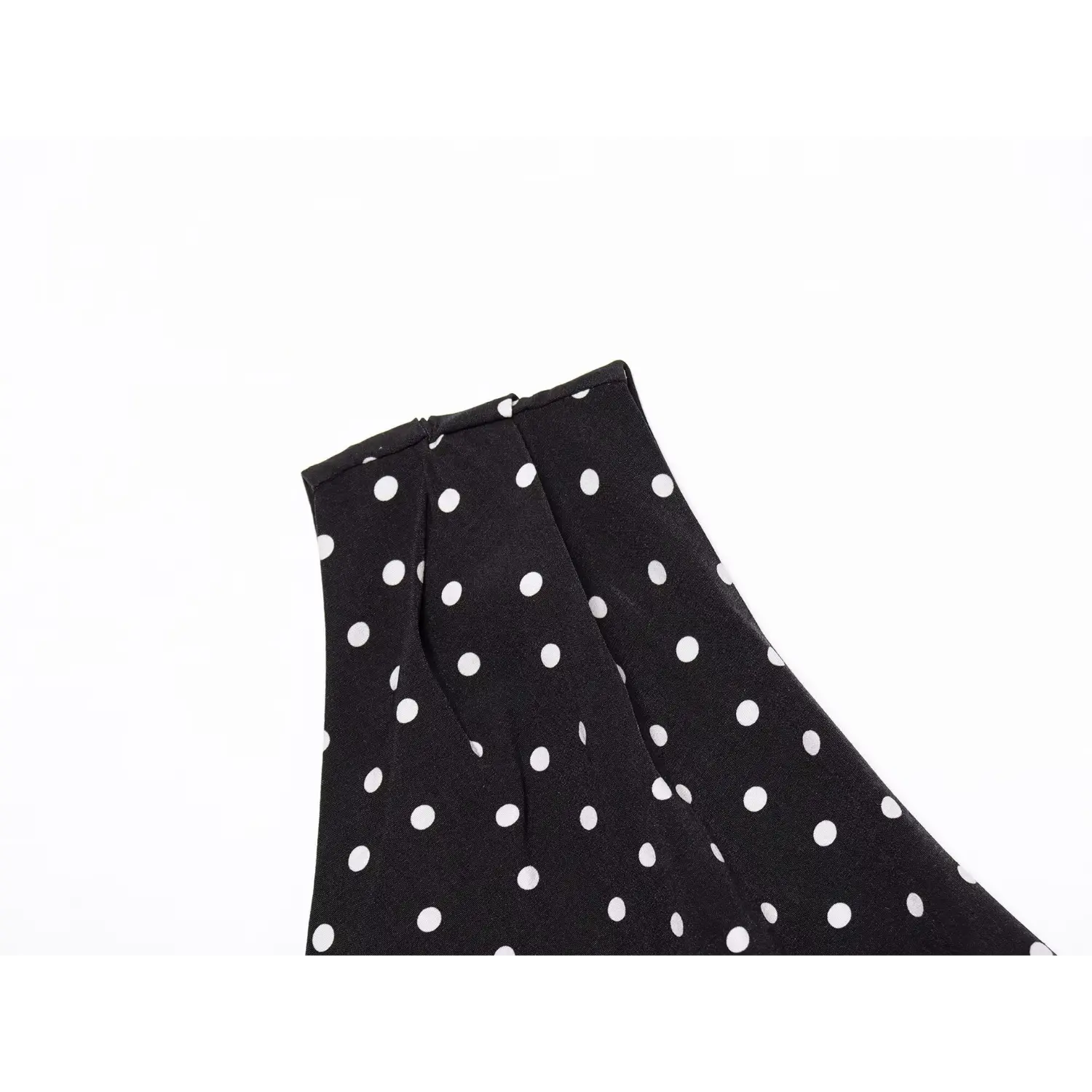 Close‑up detail of one‑shoulder seam and pleat construction polka dot black dress