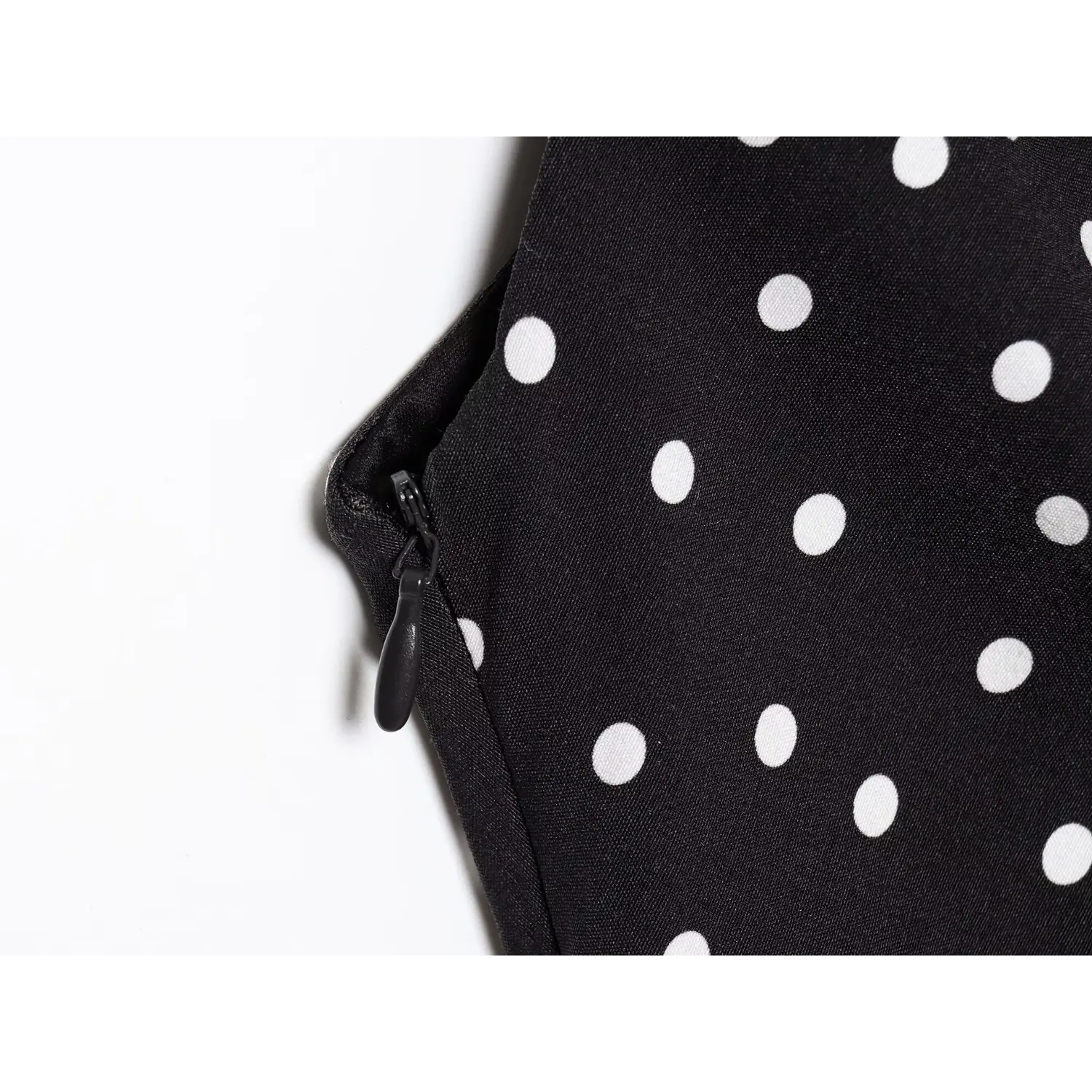 Close‑up side invisible zipper detail black white polka dot one shoulder mini dress