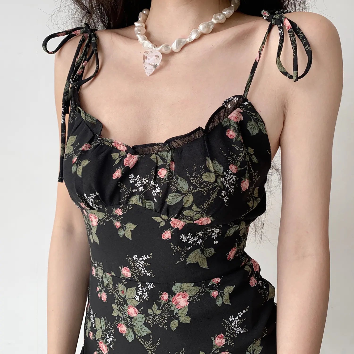 Close‑up shot bust and tie shoulder strap detail black rose floral print mini dress ruffle trim neckline