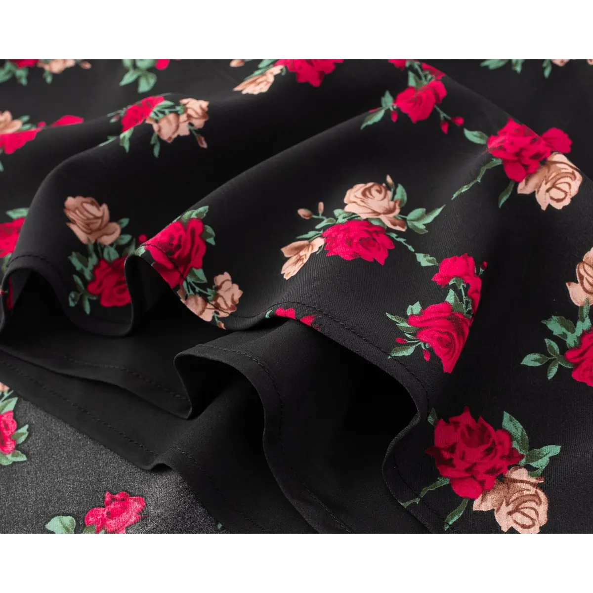 Close-up of the fabric texture and inner lining construction on the black rose print dress.