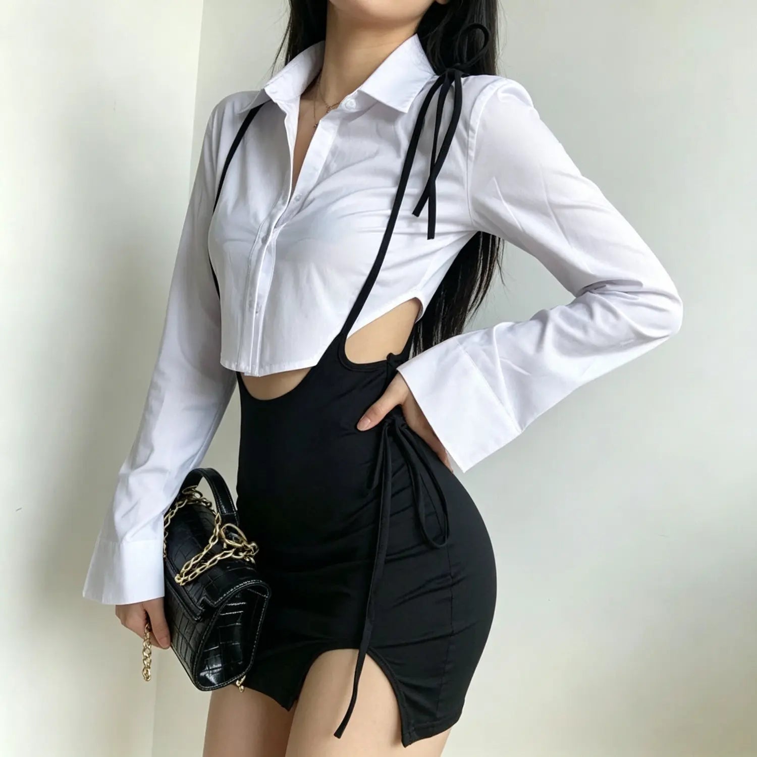 Side view model shot highlighting side tie and high side slit on black cutout suspender mini skirt