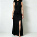 Studio model front shot black sleeveless turtleneck maxi dress with draped waist and high side slit