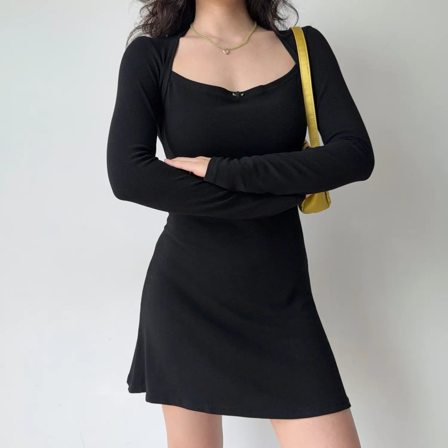 Model crossed arms pose black square halter long sleeve fitted mini dress