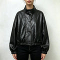 Model wearing black stand collar cropped PU jacket with black trousers