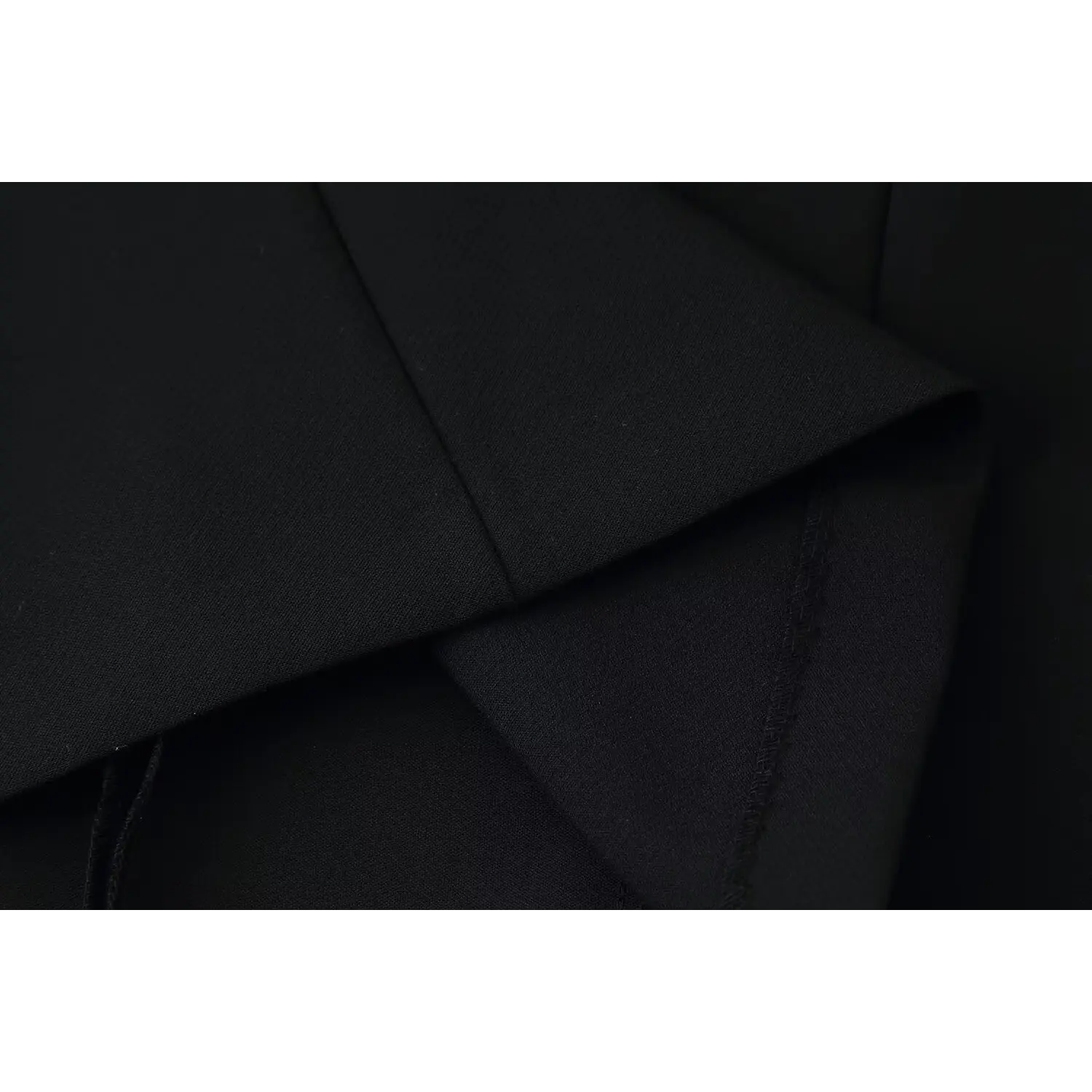 Macro shot showing stitching seam detail of black suit dress woven fabric