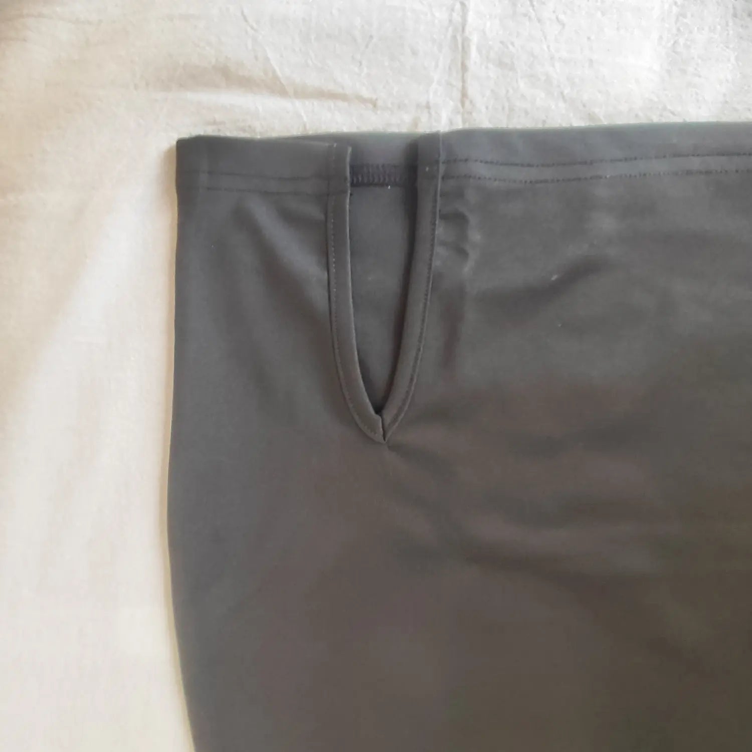 Close‑up of waist cutout and side tie opening detail on black tie strap bodycon mini skirt