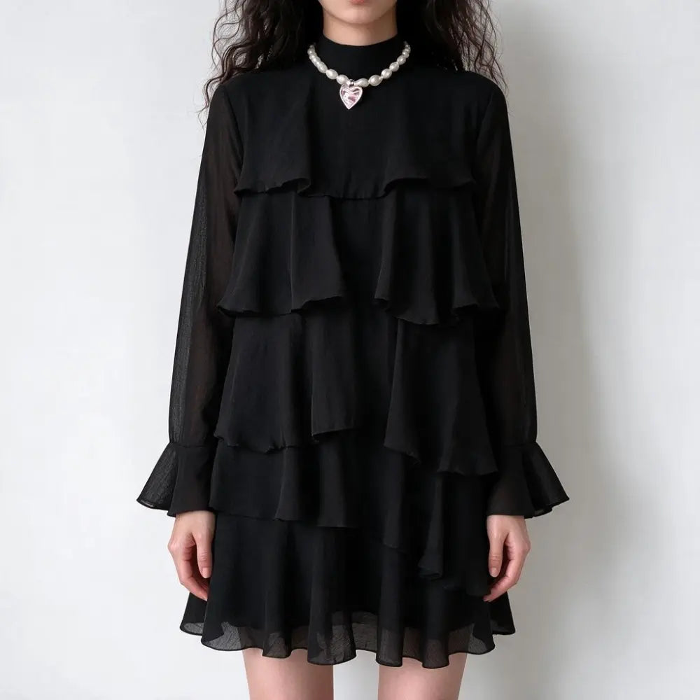 Model wearing black tiered ruffle high neck mini dress, front view