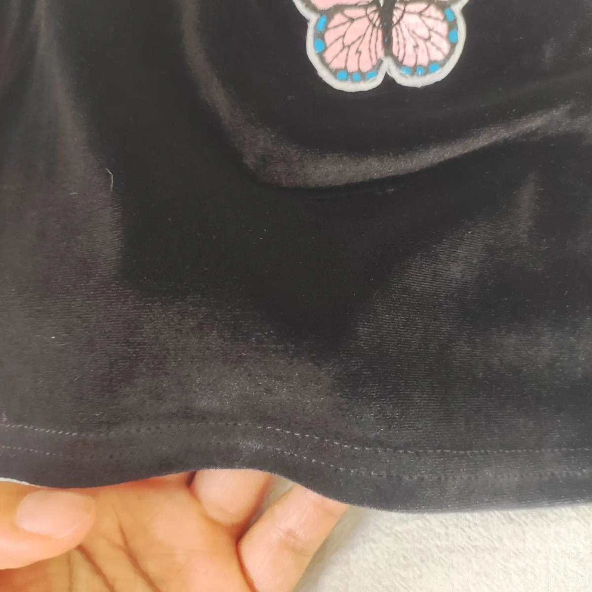 Close‑up bottom hem fabric and stitching black velvet halter crop top