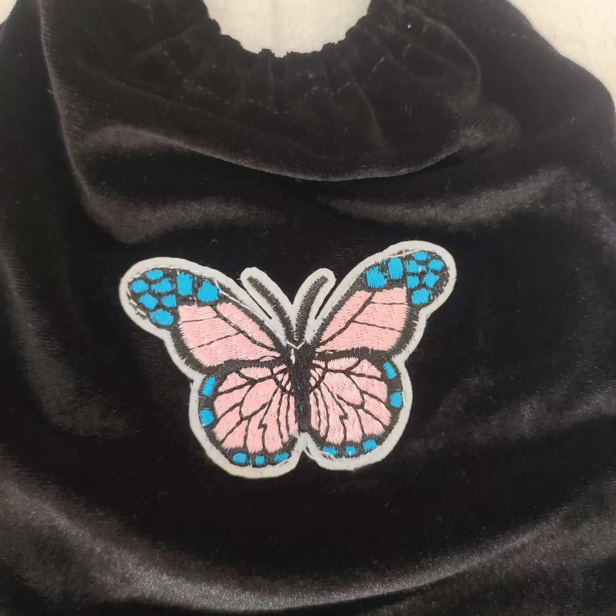Close‑up butterfly embroidery patch detail black velvet halter crop top