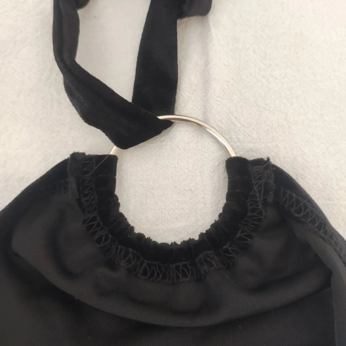 Close‑up metal ring hardware and elastic neckline black velvet halter crop top