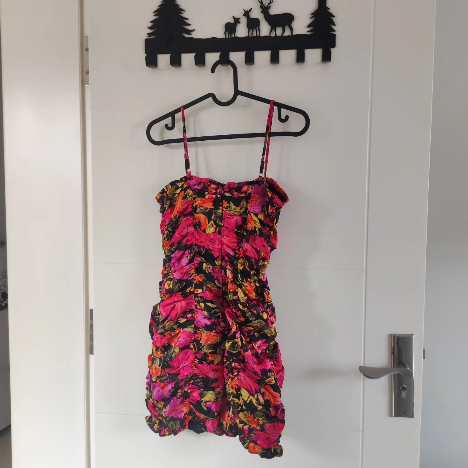 Hanging back view black base pink orange floral all‑over print ruched cami mini dress