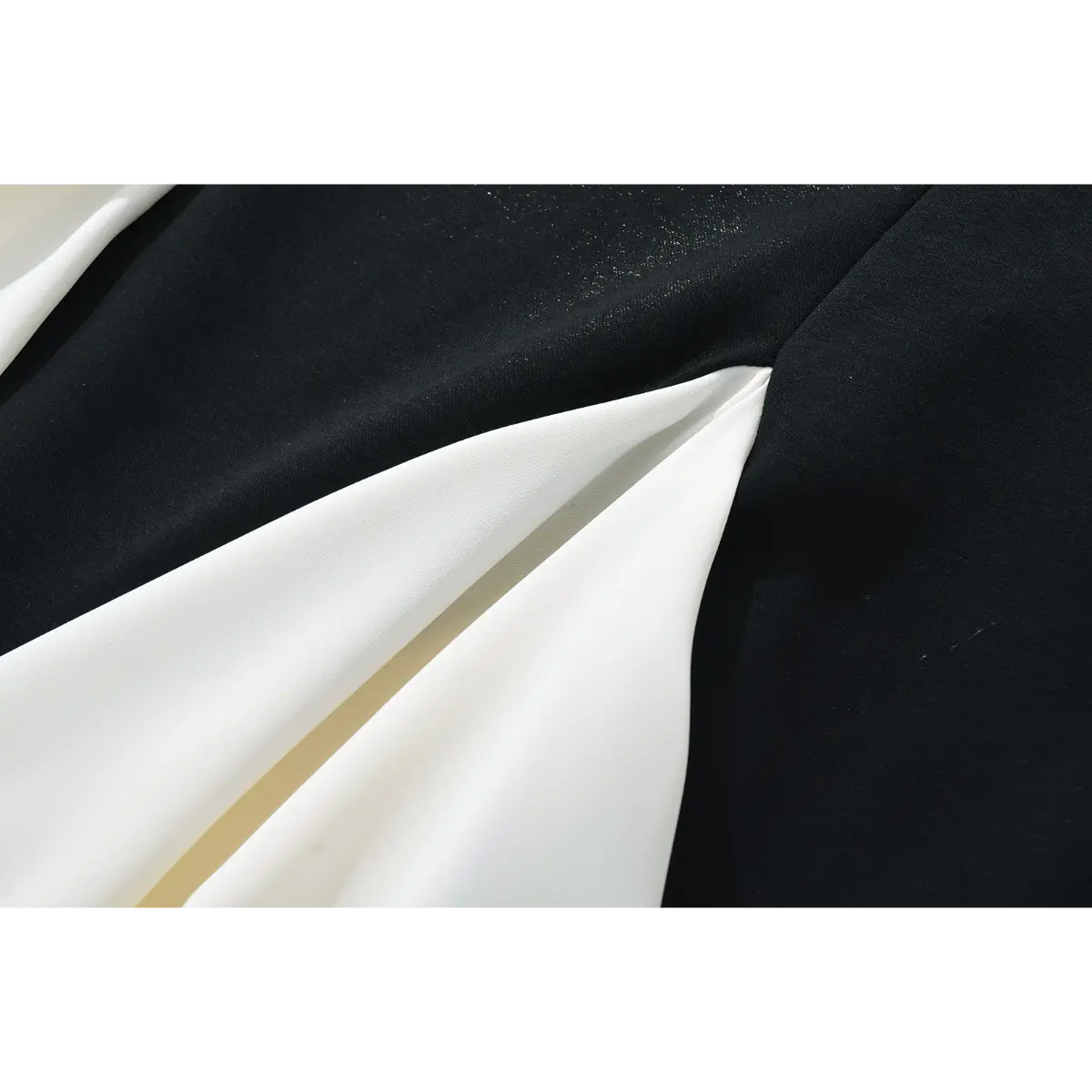 Close-up of the fabric construction and pleated seam where the black and white panels meet.
