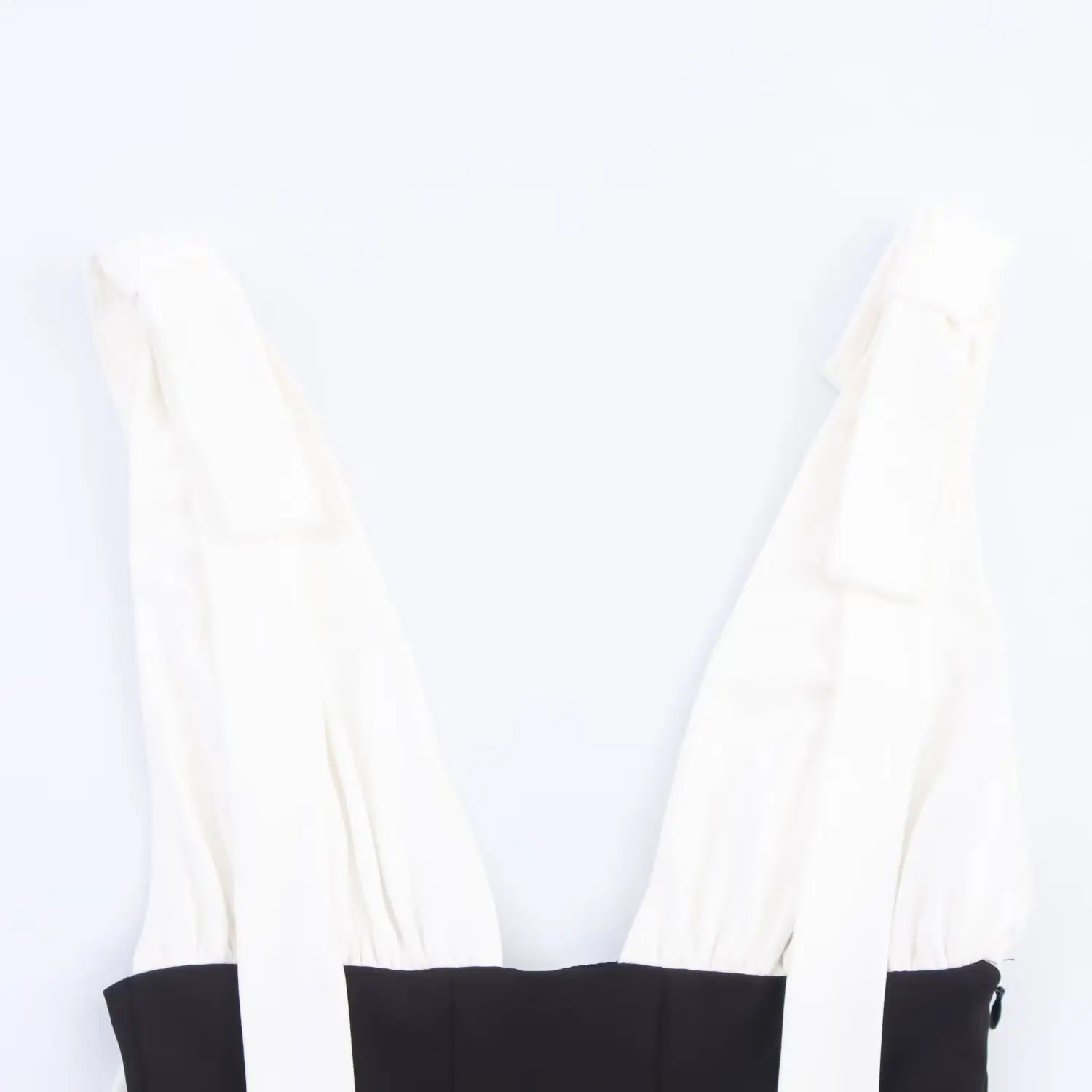 Partial front view showing the deep V-neckline and both bow-tie shoulder straps