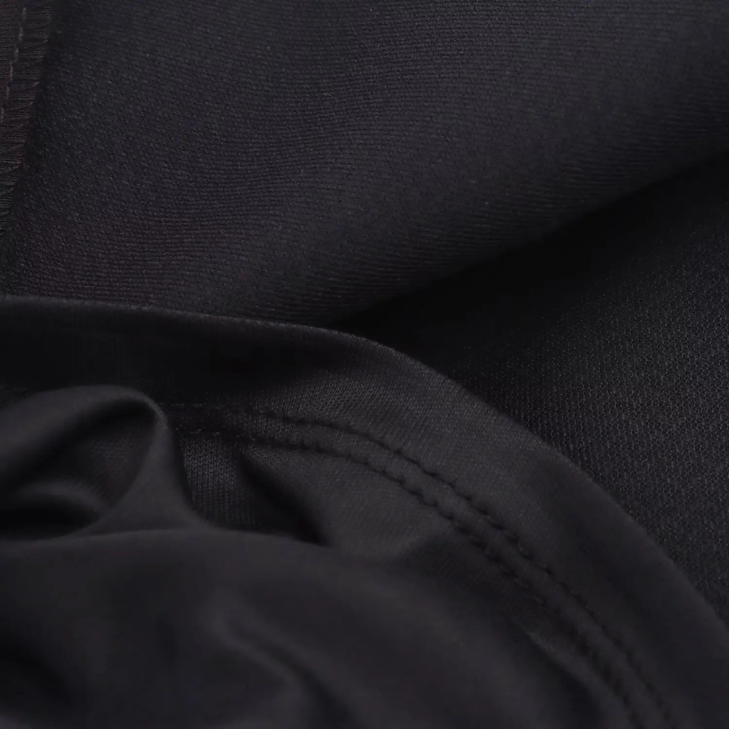 Close-up of the inner seam and overlocked stitching on the black bodice fabric