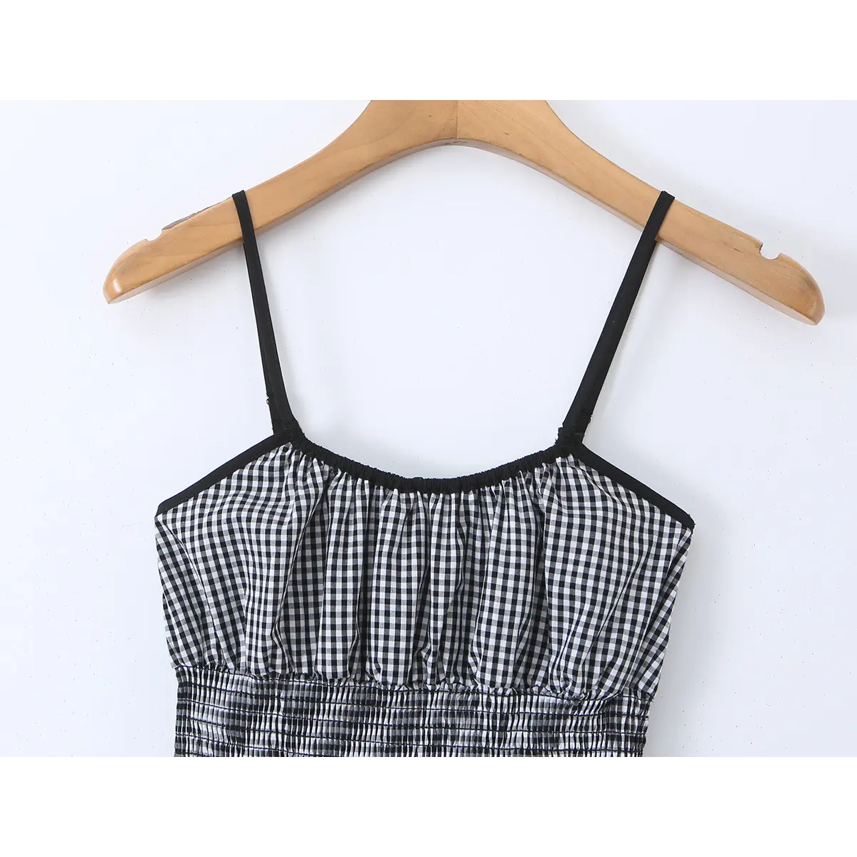 Close-up front view of the bust, straps, and neckline trim on the gingham dress.