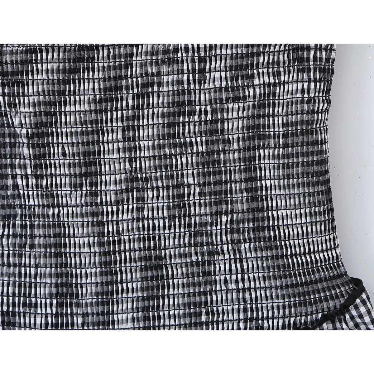Close-up of the smocked back panel and texture on the gingham cami dress.