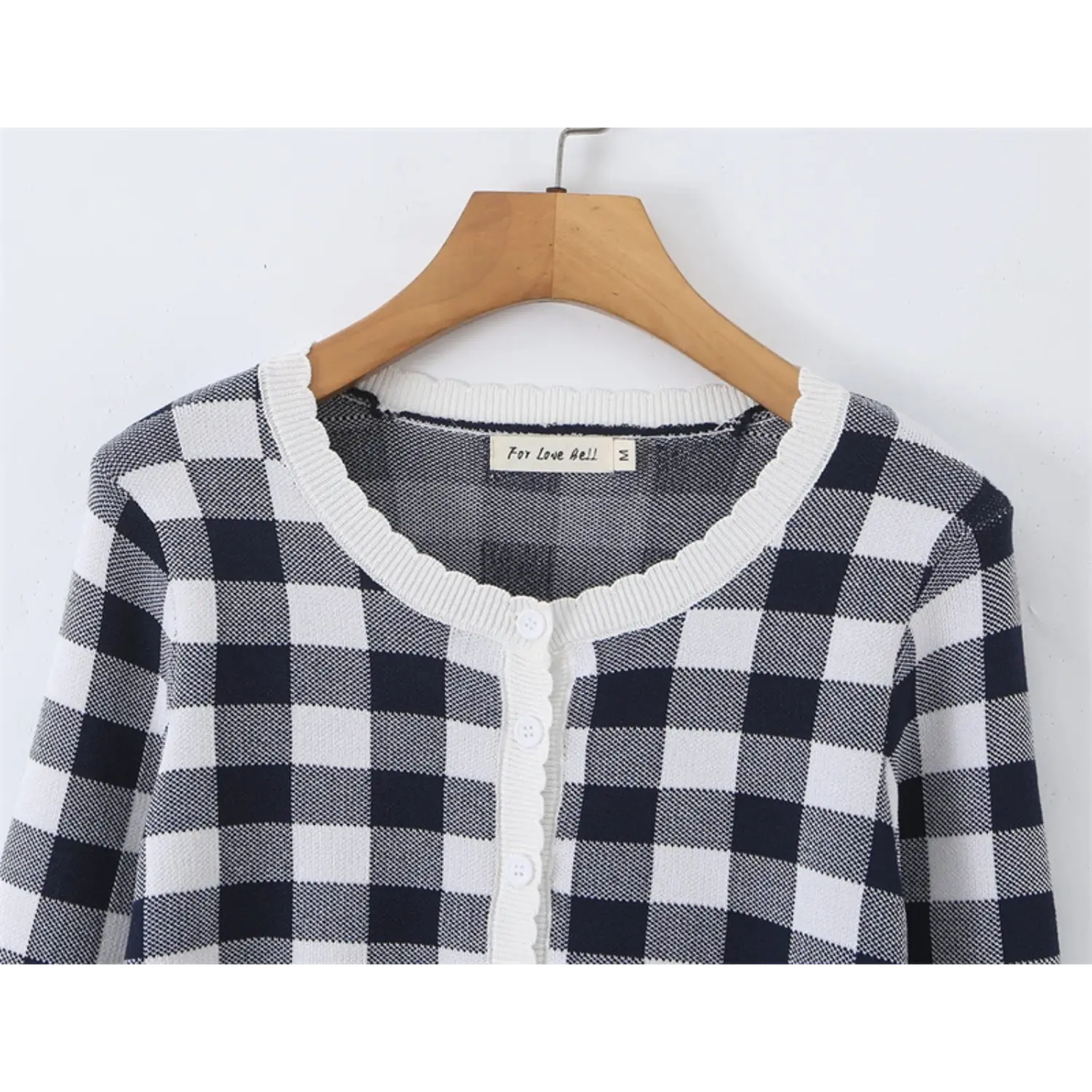 Closeup round scalloped rib neck, inner fabric size label, full black white gingham knit fabric, vertical front button placket overview