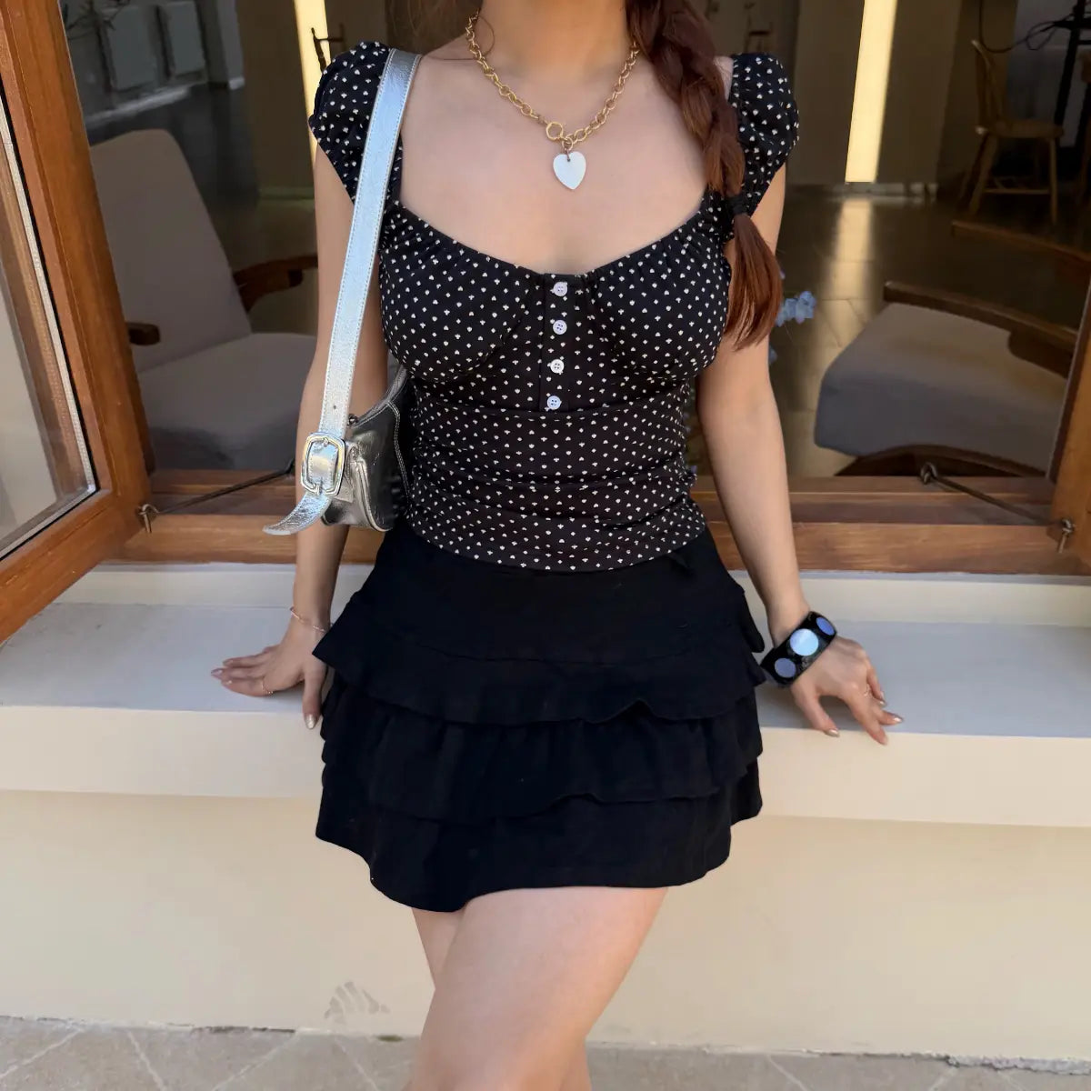 The complete outfit, showing the top paired with a tiered black ruffled mini skirt.