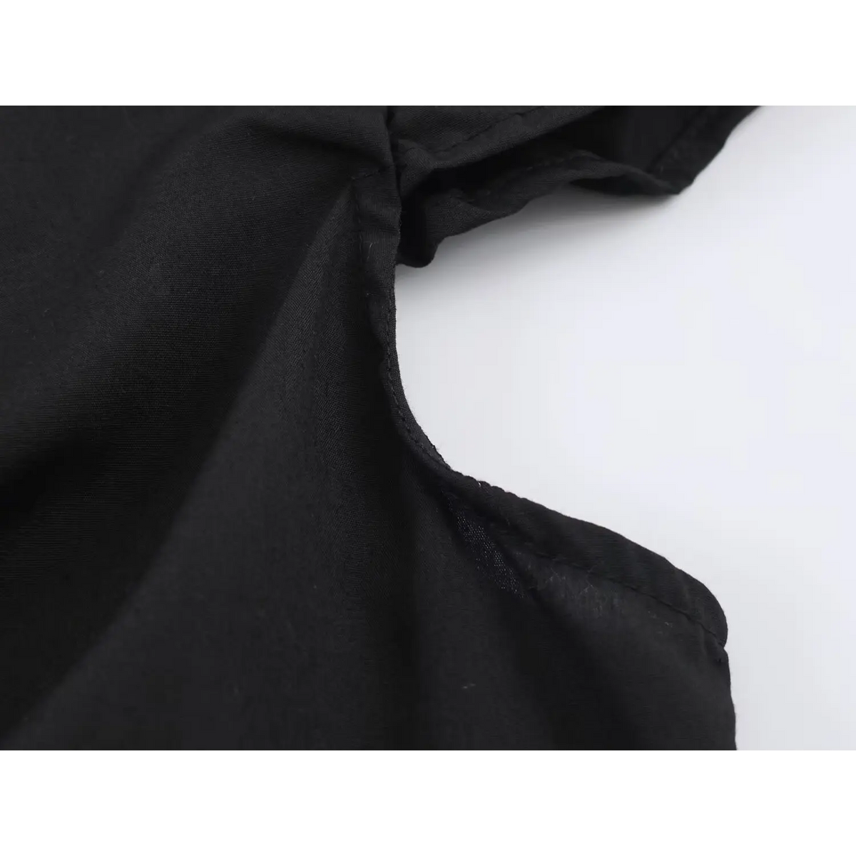 Close-up of shoulder and ruffle sleeve seam on black peplum top