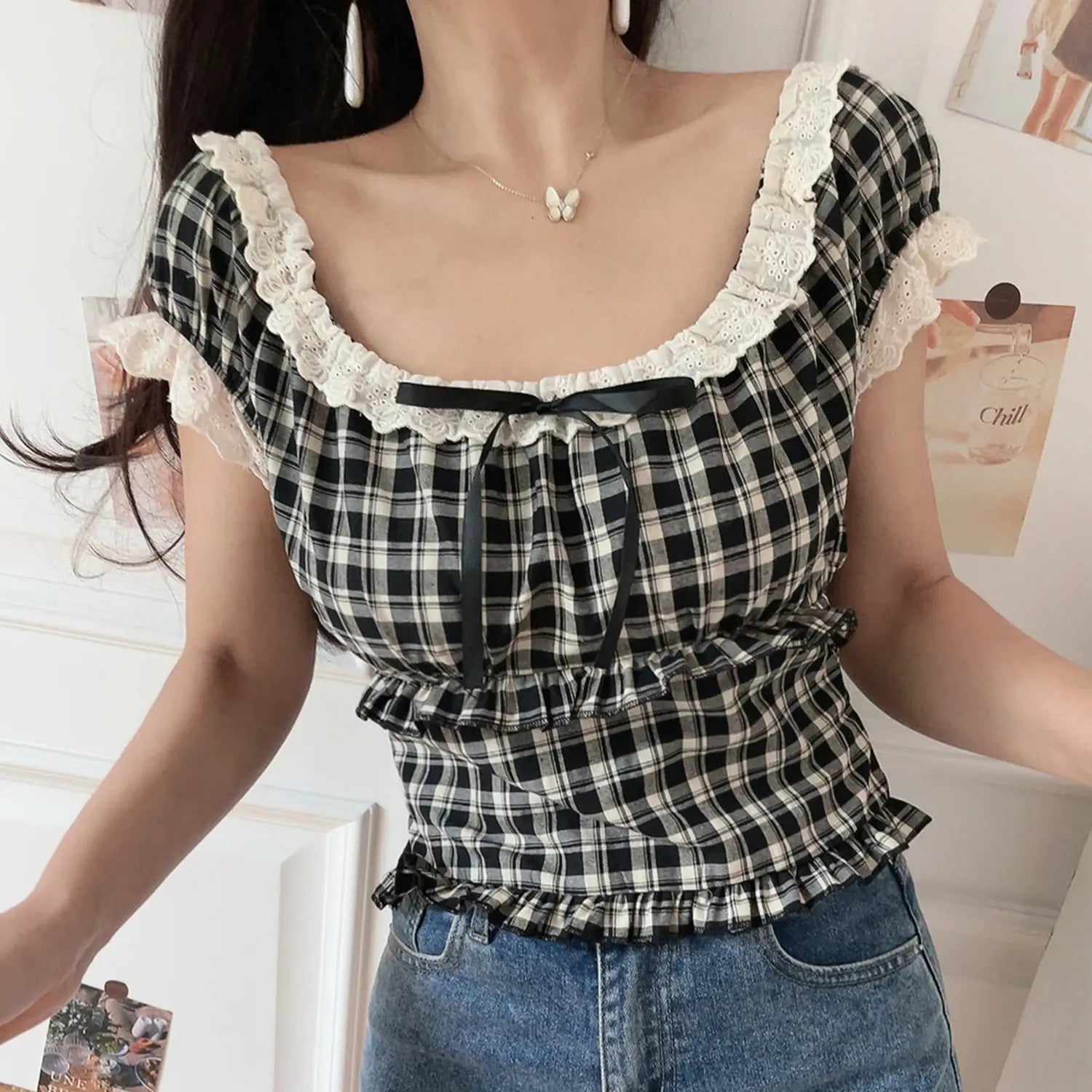Women black white plaid lace trim crop top, front tie ruffle hem with denim pants indoor model shot