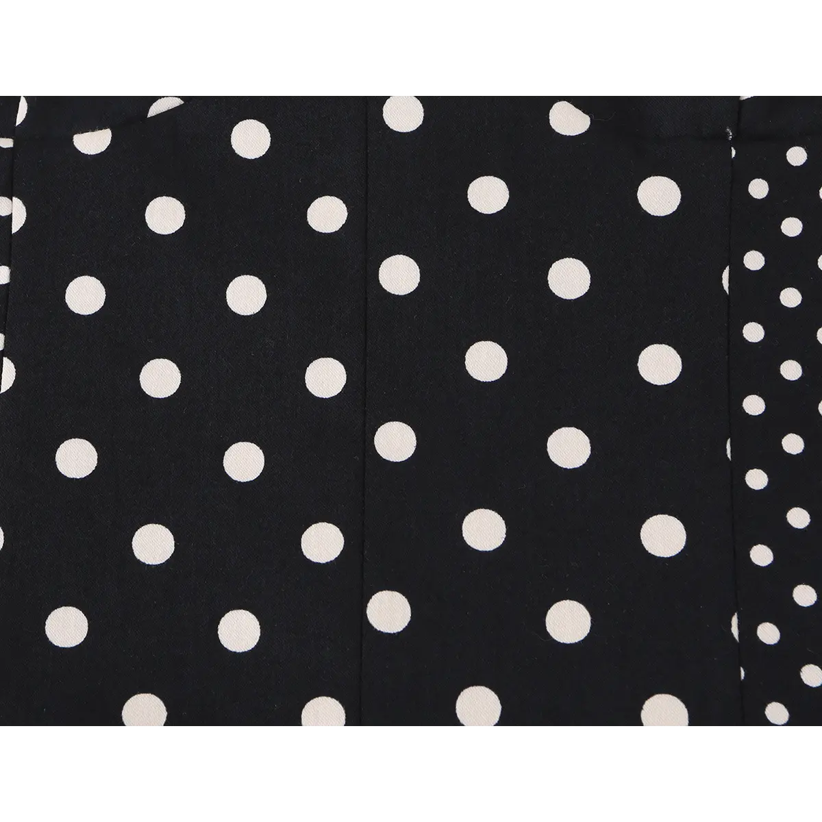 Close-up detail of the polka dot pattern and vertical seams on a black and white bustier crop top.