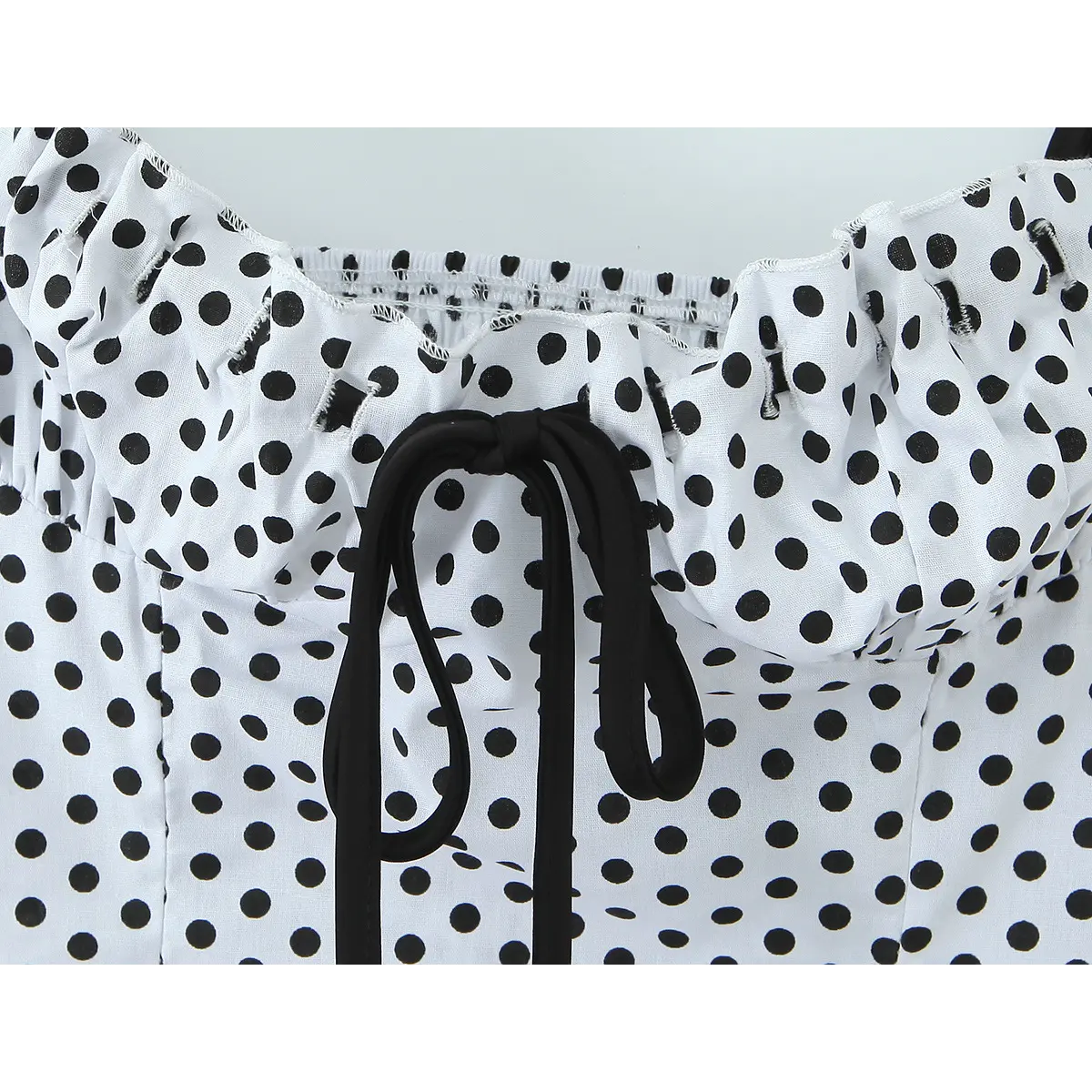 Close-up of the black drawstring tie at the bust, with ruffled trim detail.