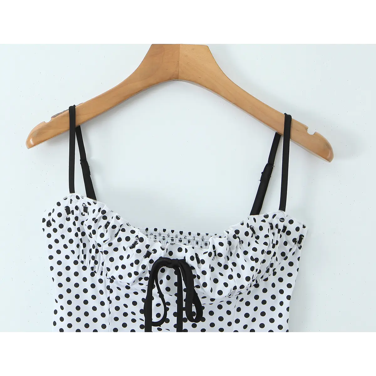  Full view of the polka dot camisole, highlighting the adjustable straps and cropped silhouette.