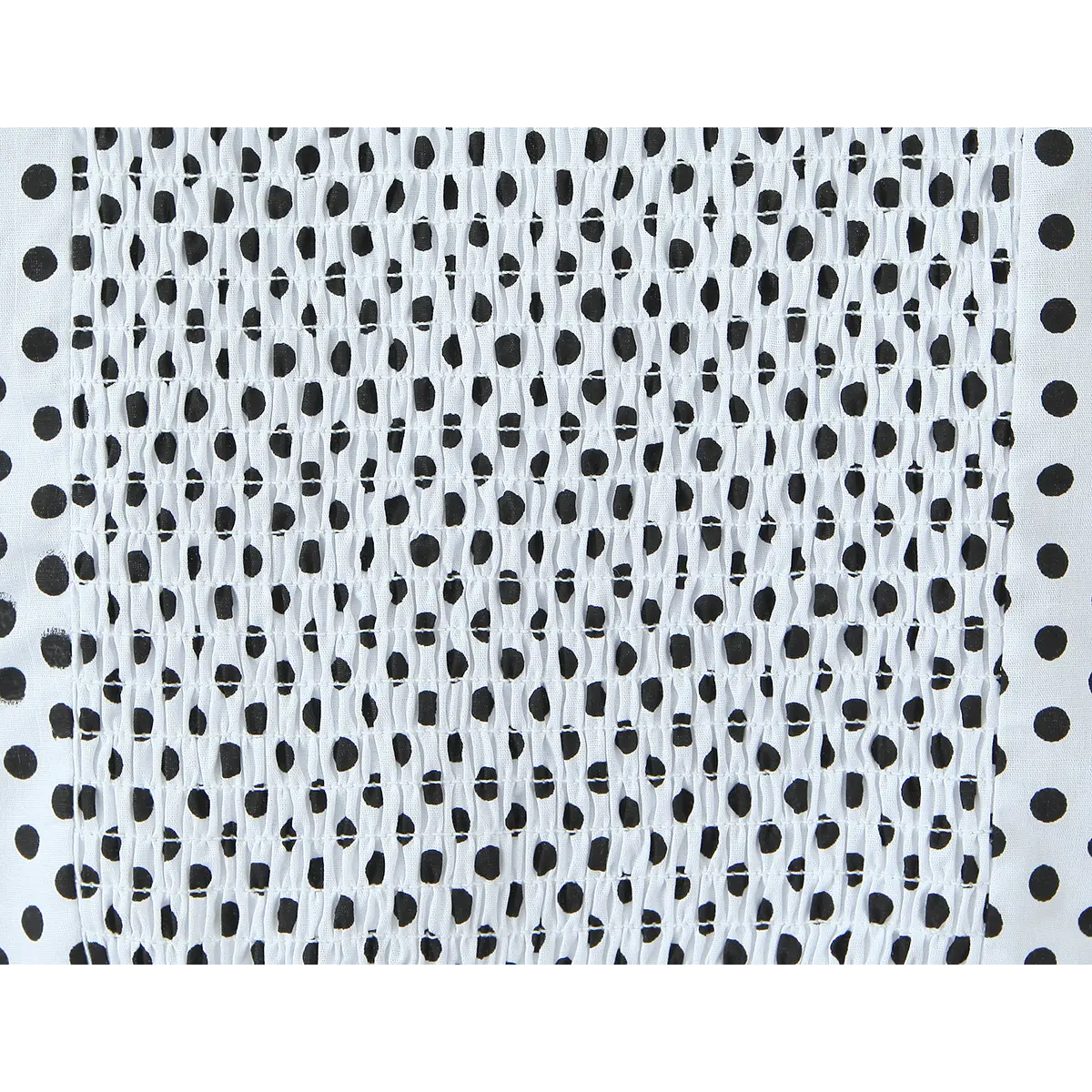 Close-up of the smocked elasticated bust and all-over polka dot print on the camisole.