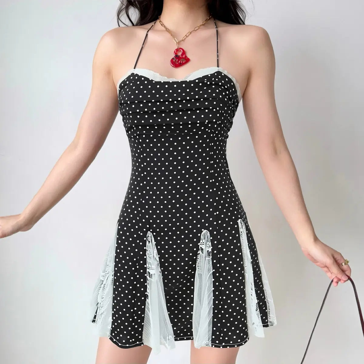  On-model view of the dress, showing the halter neck, fitted bodice, and lace-paneled skirt silhouette.