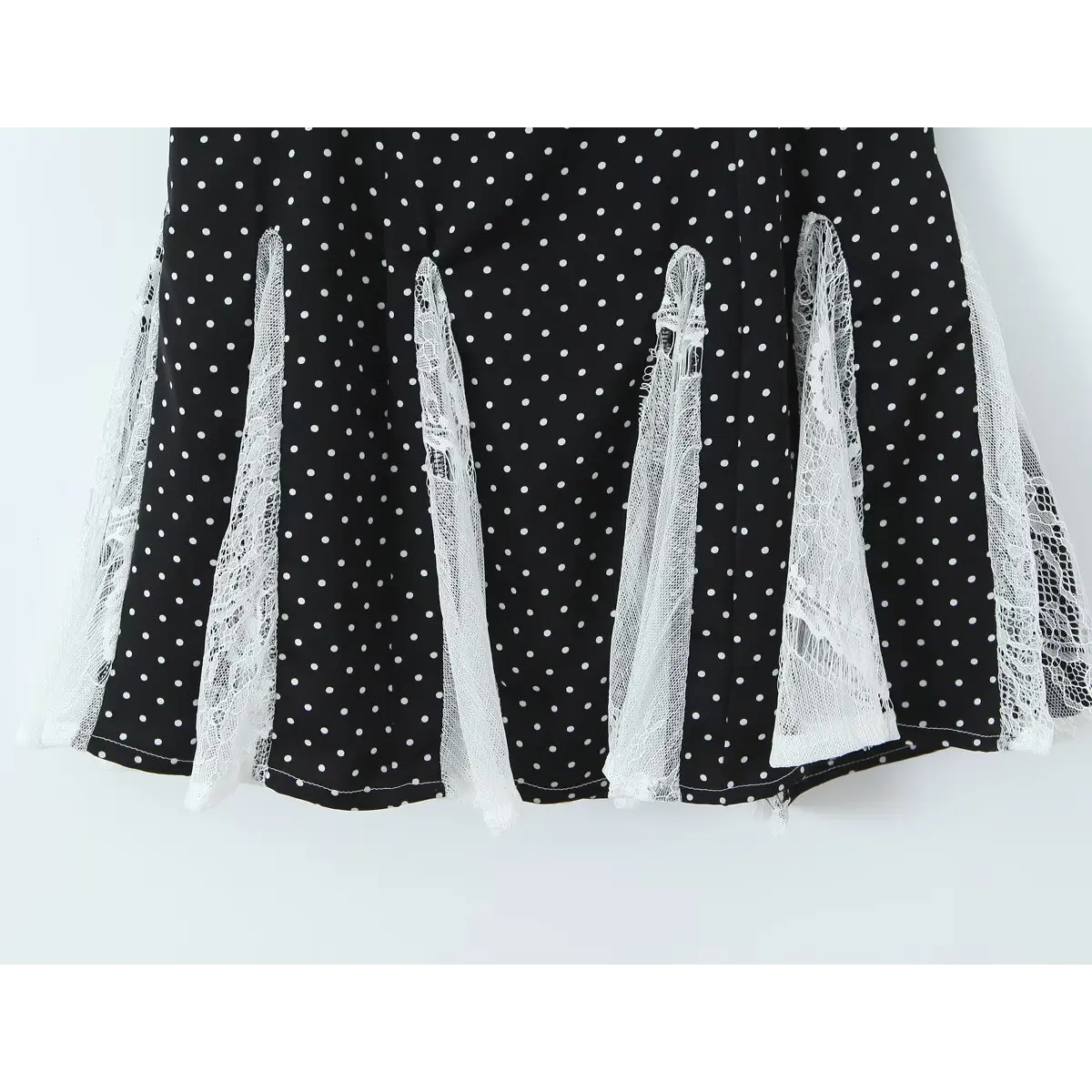  Close-up of the skirt hem, showing the polka dot fabric and lace panel edges.