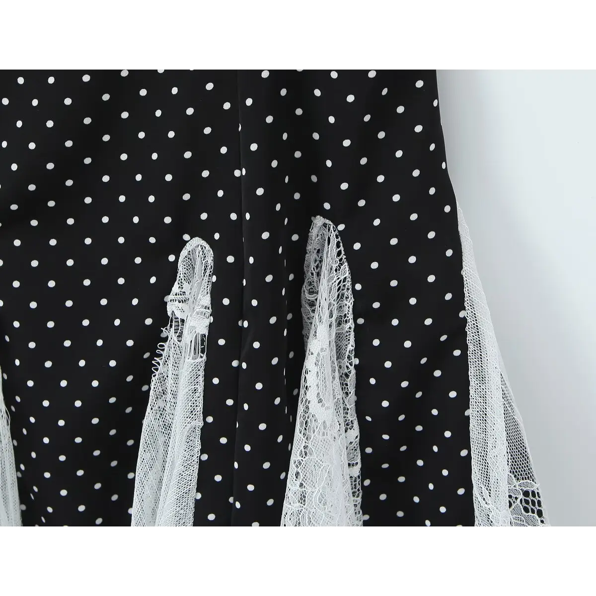  Close-up of the vertical lace panels in the skirt, showing the contrast between polka dot fabric and white lace.