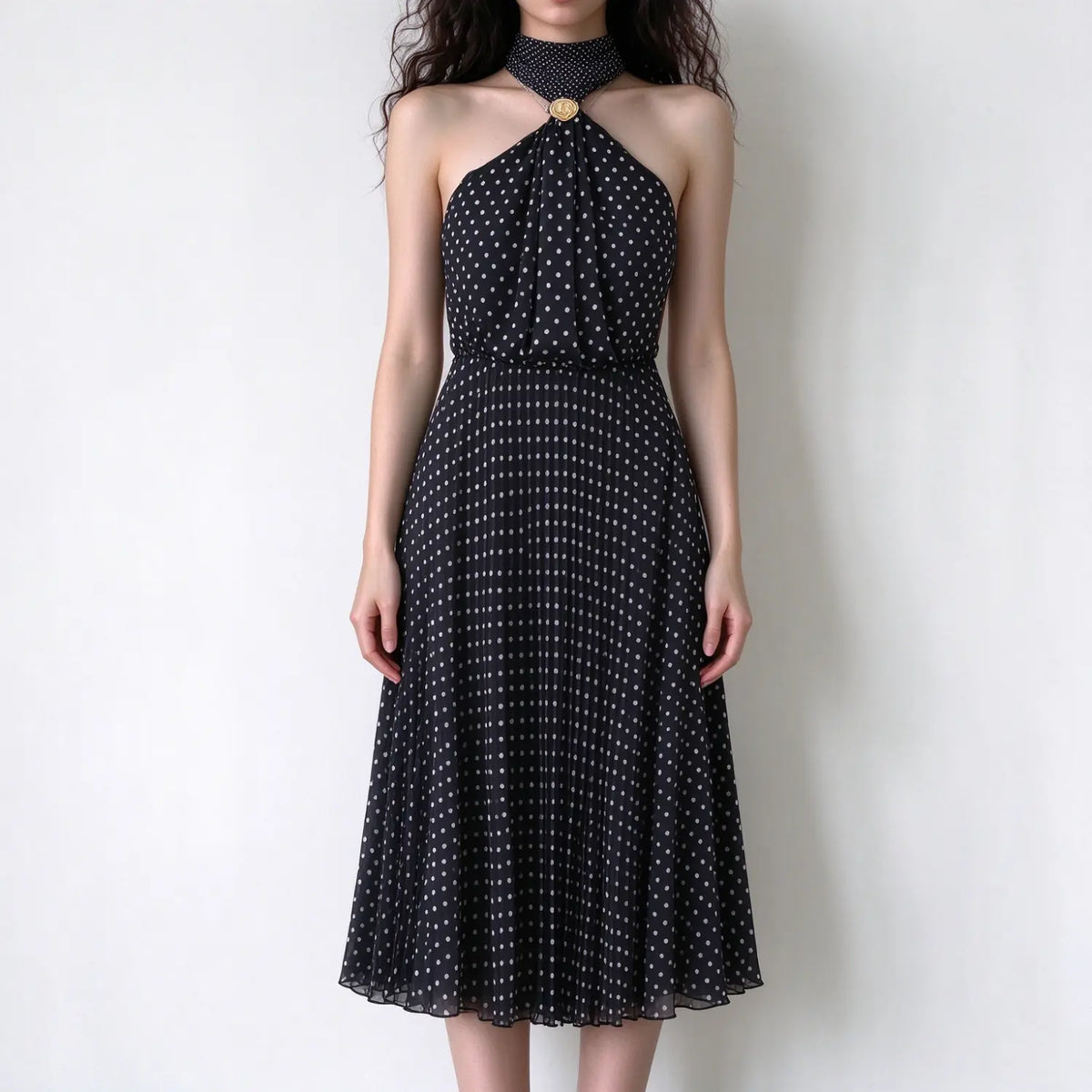 Model wearing black white polka dot halter maxi dress, pleated chiffon fabric, fitted waist, flowy maxi skirt, white background
