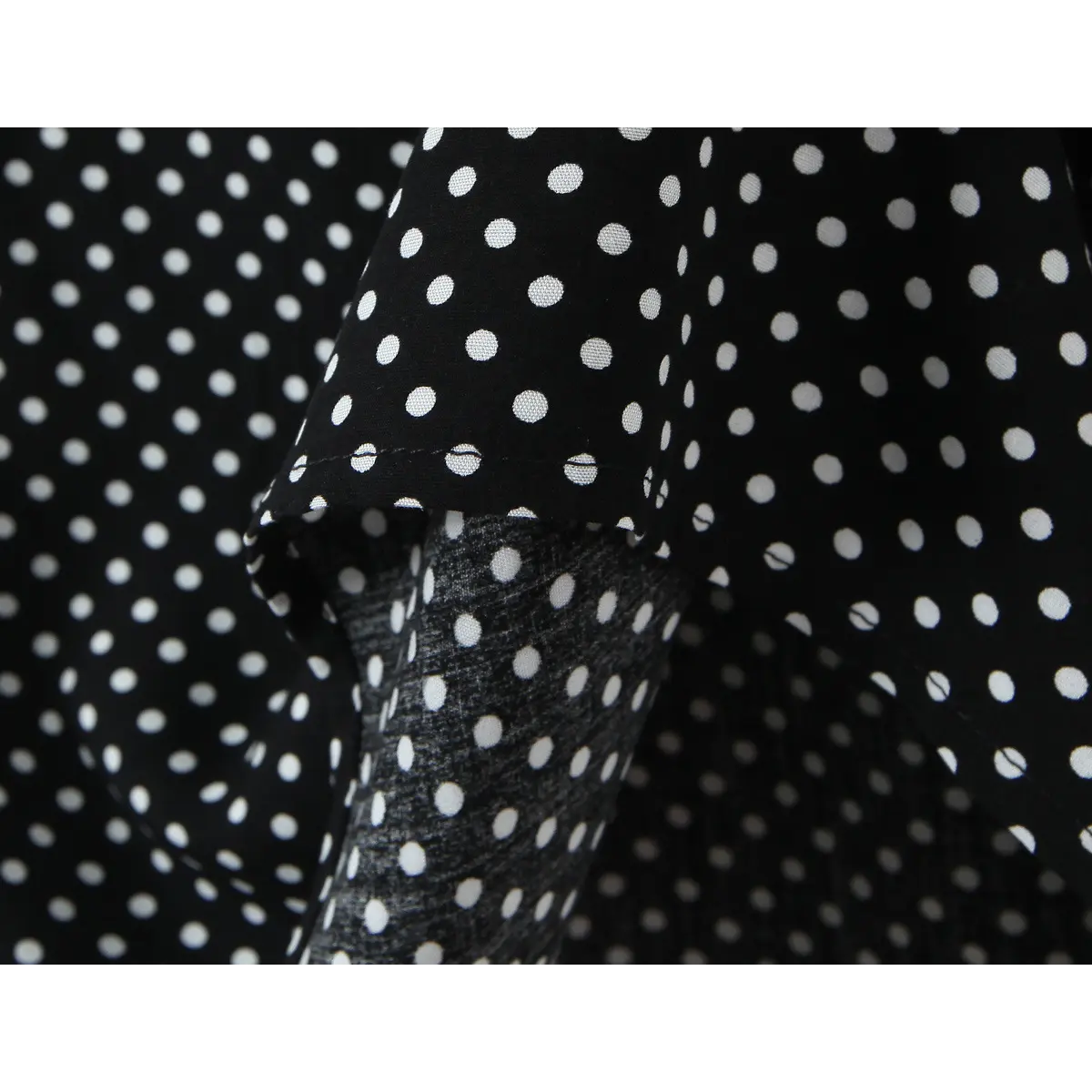 Close-up of the polka dot fabric, showing the texture and inner lining.