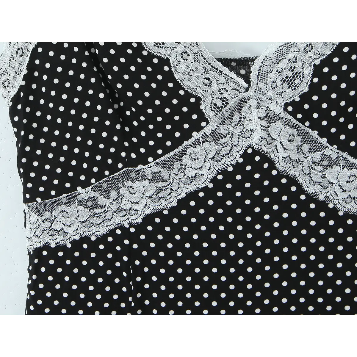 Close-up of the waistband lace trim, showing the scalloped edge and polka dot fabric.