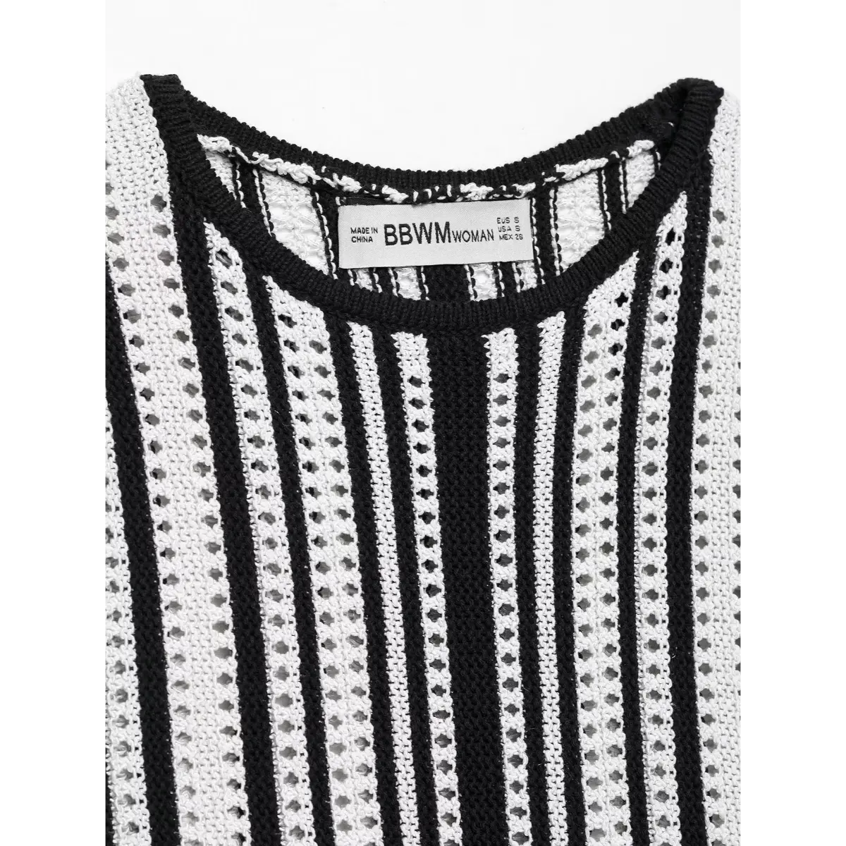 Close-up view of the round neckline and woven label on a black and white striped knit mini dress, showing the openwork texture.
