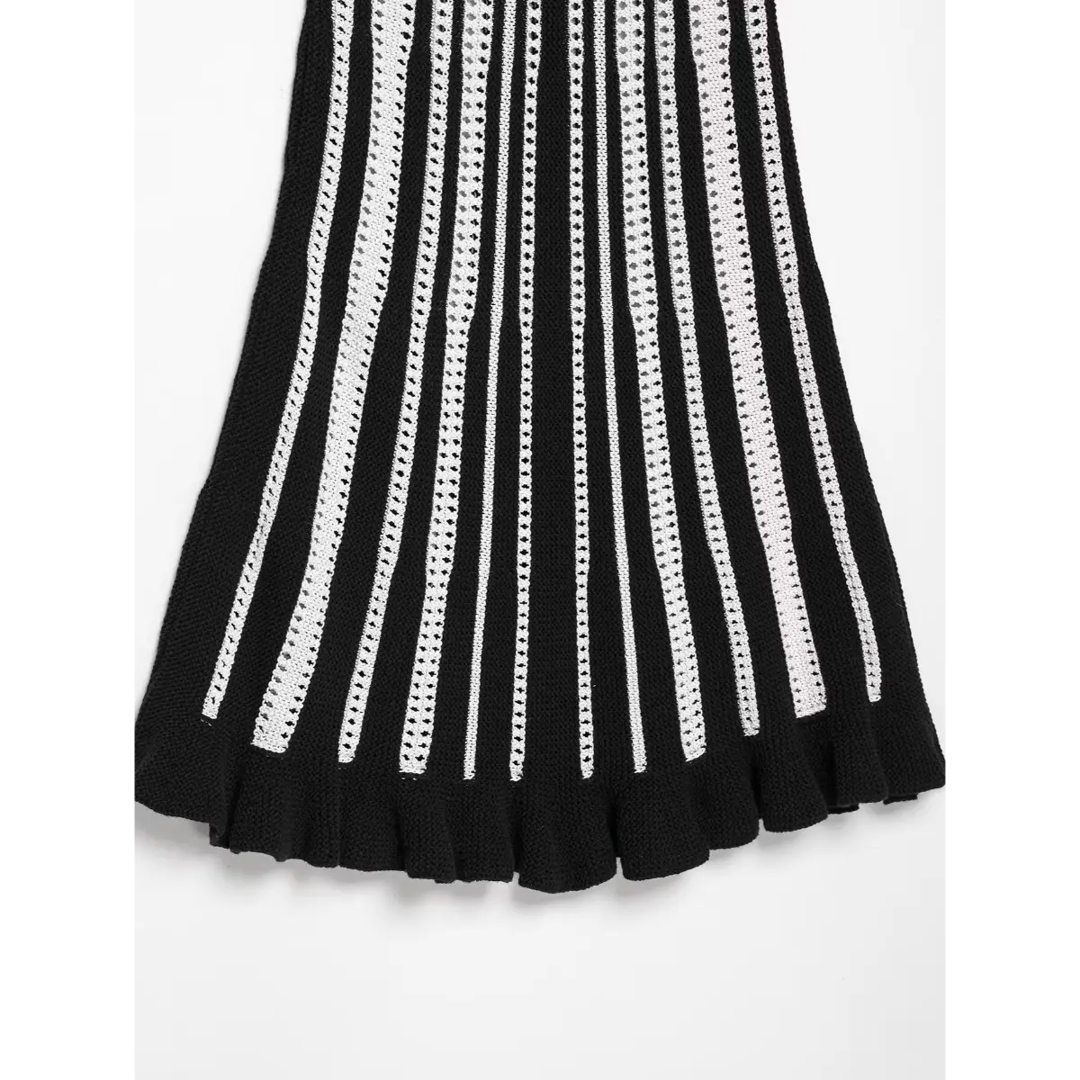 Close-up view of the ruffled hem on a black and white striped knit mini dress, showing the textured knit trim.