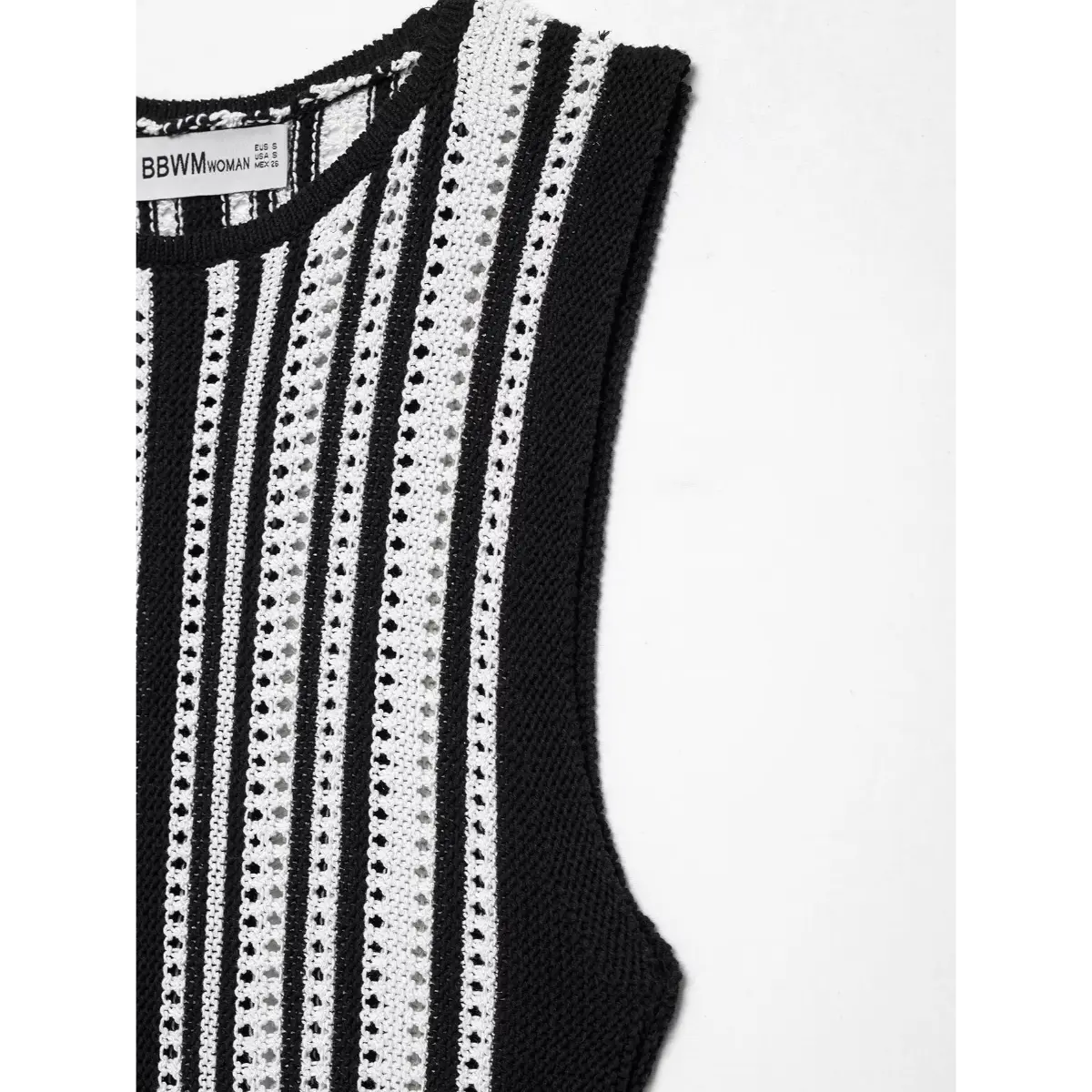 Close-up view of the armhole and neckline on a black and white striped knit mini dress, highlighting the ribbed edge and woven label.
