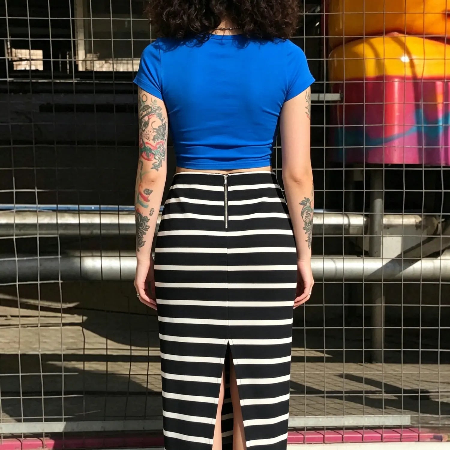 Back view model photo striped midi skirt with rear gold zipper and back slit