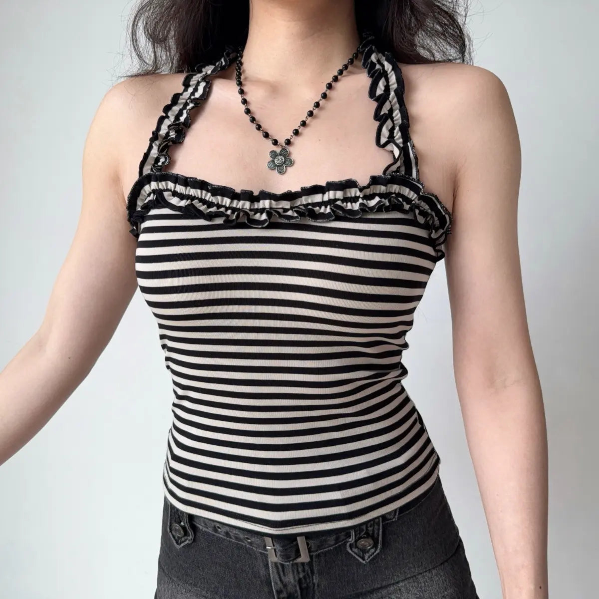 The top styled with a black beaded flower necklace, showing the neckline detail.