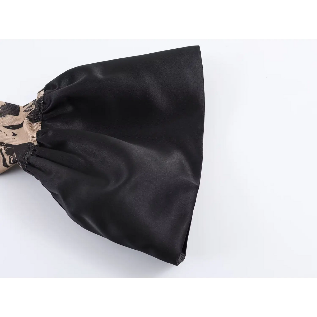 Close‑up of black satin flared bell sleeve cuff,gathered ruffle design