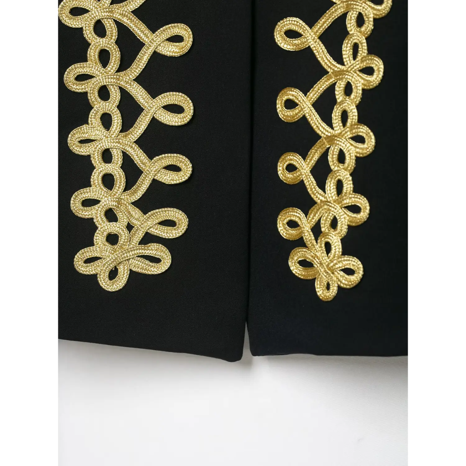 Close‑up front hem gold braid embroidery detail of black military blazer
