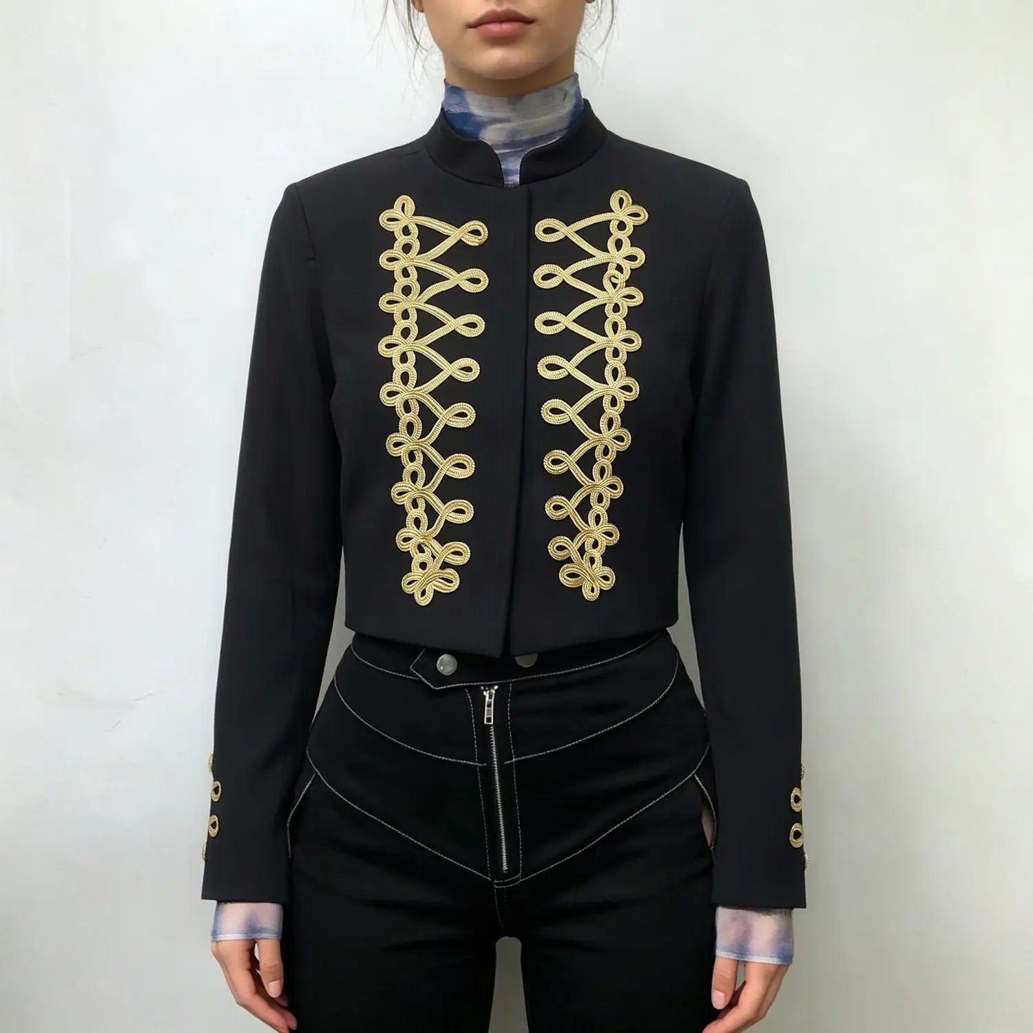 Model wearing front view black cropped military blazer with gold braid embroidery