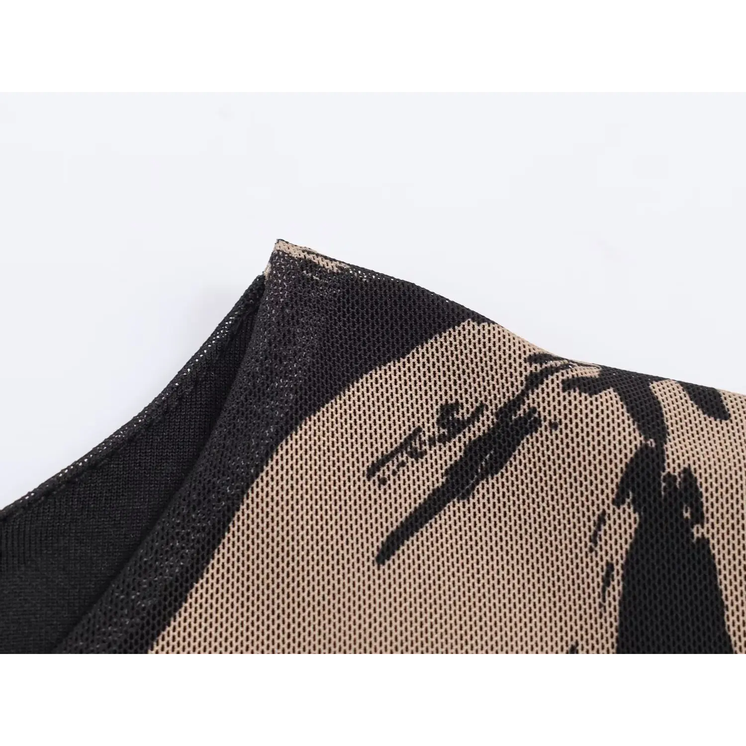 Close‑up collar stitching and mesh fabric with abstract flower print