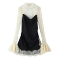 Front flat lay of black satin mini dress with cream lace mock neck bell long sleeve overlay, ruched skirt, scalloped lace hem