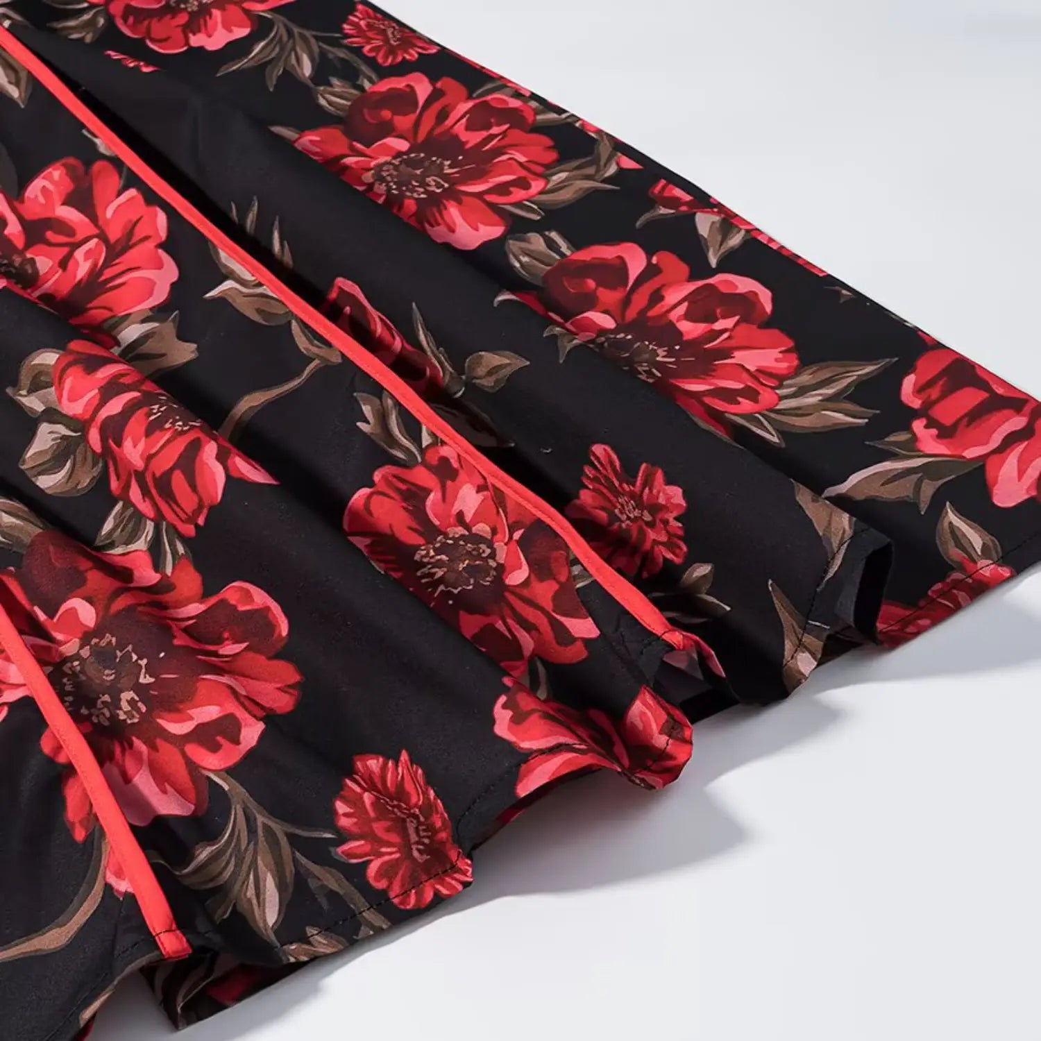 Close‑up of red floral print fabric and red piping on skirt